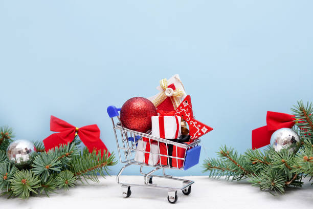 istock Shopping trolley with christmas gift boxes and decorations on blue background. Christmas and New Year sale. 1289906493
