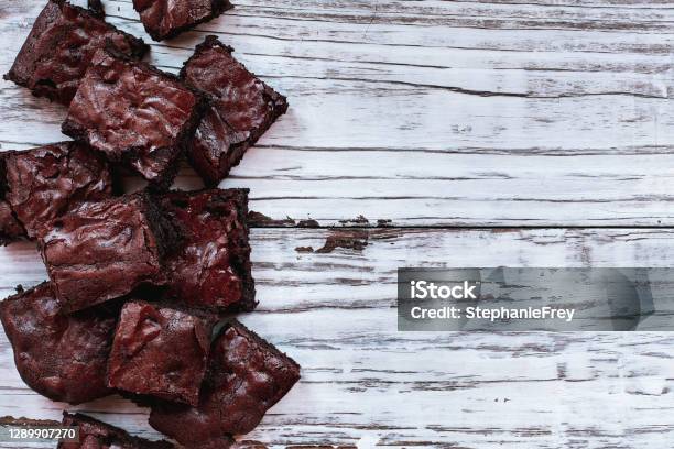 Squares Of Delicious Homemade Fudgy Brownies Stacked A White Rustic Wooden Table Background Stock Photo - Download Image Now