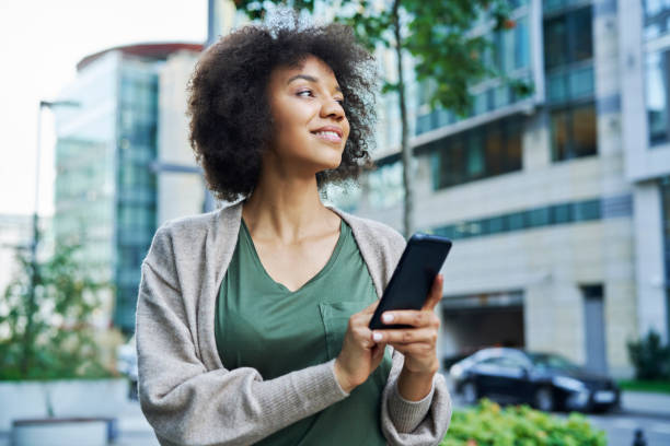 istock African woman looking around while holding the phone 1289907327