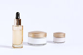 A set for the care of the skin around the eyes and skin consisting of glass jars of cream and a bottle with a serum pipette