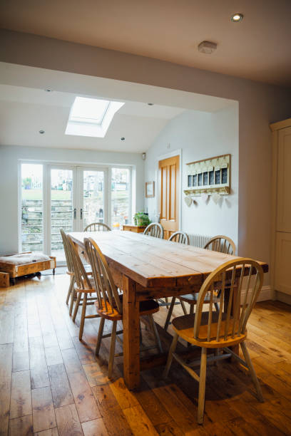 Country Style Dining Room Table And Kitchen A wide angle view of a country style kitchen in a family home in Northumberland in the North East of England with a long dining table for a large family. breakfast room stock pictures, royalty-free photos & images