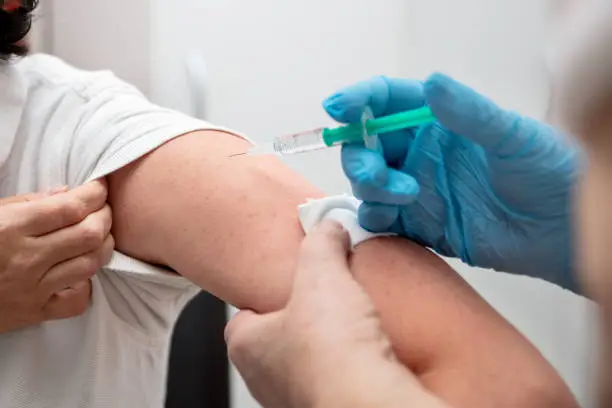 a female nurse or doctor is vaccinated against the coronavirus or covid-19, maybe flu vaccination