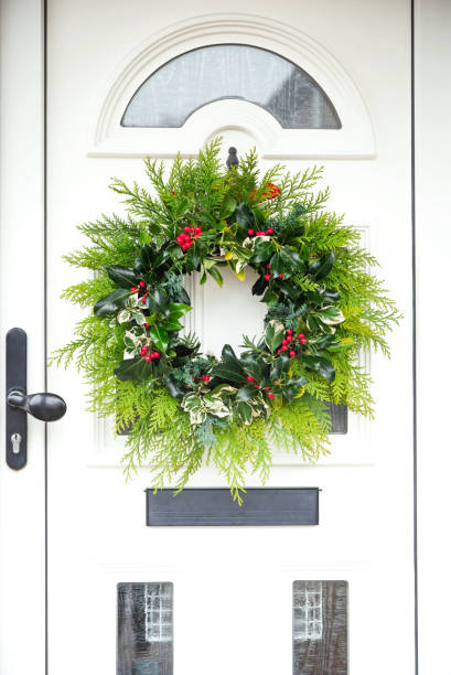 istock Handmade fresh foraged winter wreath hanging on the front door 1289911683