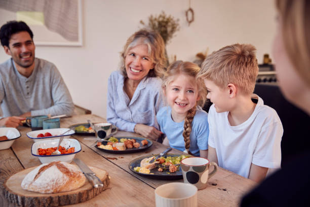 istock Multi-Generation Family Sitting Around Table At Home In Pyjamas Enjoying Brunch Together 1289915571