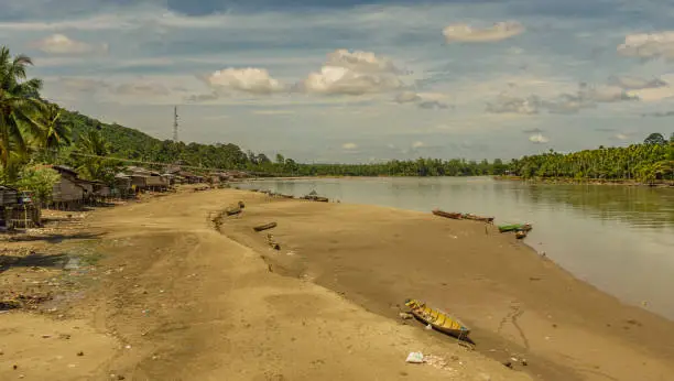 Village by the river scene next to big mountains and jungle