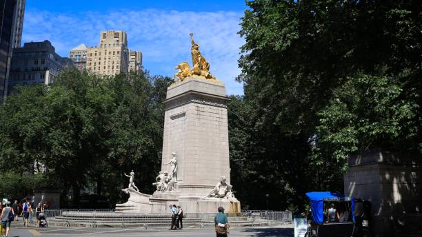 USS Maine National Monument in Central Park New York, NY, USA - Dec 7, 2020: An outdoor memorial with a stone base and gold leaf images on top merchants gate stock pictures, royalty-free photos & images