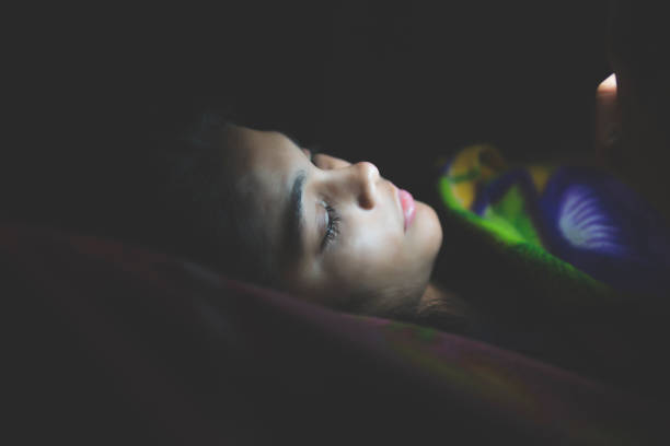 istock Girl using smart phone at night in bed. 1289919852