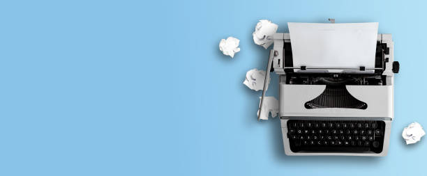 istock old typewriter and crumpled paper balls on blue background 1289920869