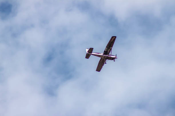 prop plane  flying overhead in mottled cloudy blue sky - Room for copy.
