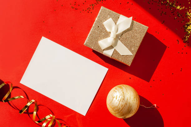 istock Gold gift and blank form for congratulations on a red background. Flat lay style. Christmas time 1289922026