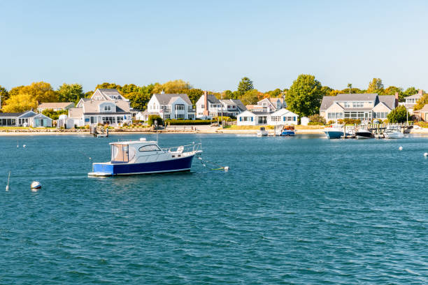 motoscafo ormeggiato al largo di una costa edi costruita in una soleggiata giornata autunnale - cape cod foto e immagini stock