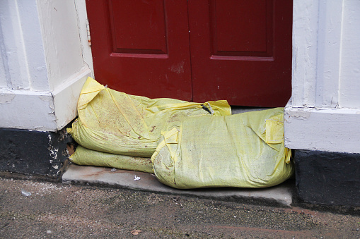 Sandbags piled against the door of a house in Shrewsbury Shropshire in an attempt to prevent storm waters entering and ruining the treasured belongings inside.