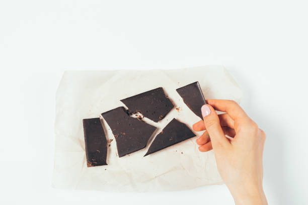 istock Top view woman's hand taking piece of organic dark chocolate 1289926341