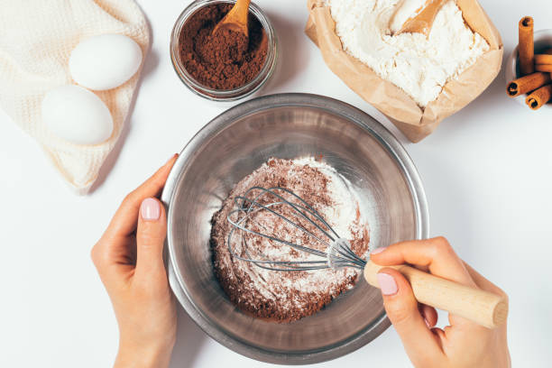 руки женщины венчиком муки и какао-порошка в миску - dessert spice baking cooking стоковые фото и изображения