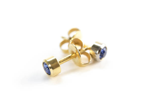 istock Gold stud earrings. Close up. Isolated on a white background 1289926747