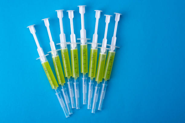 istock Several syringes with a vaccine on a blue background. View from above. 1289926913