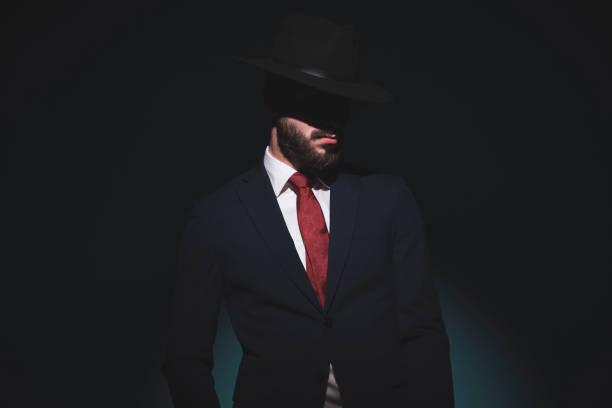 istock mysterious businessman hidding his face under his hat 1289928283