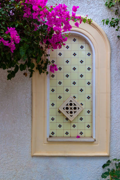 istock Decorative walled up arched window with a bougainvillea branch 1289928937