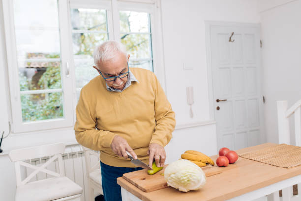istock Senior man chopping vegetables for lunch 1289929031