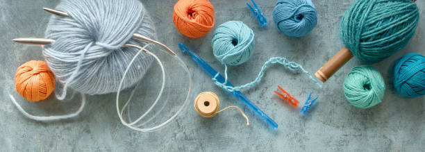 istock Various wool yarn and knitting needles, creative knitting hobby. Panoramic background on mint green 1289929054