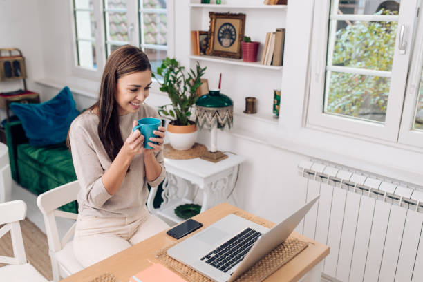 istock Young woman enjoying coffee and working from home 1289929110