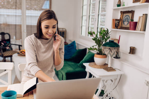 istock Beautiful woman having a business call while working from home 1289929113