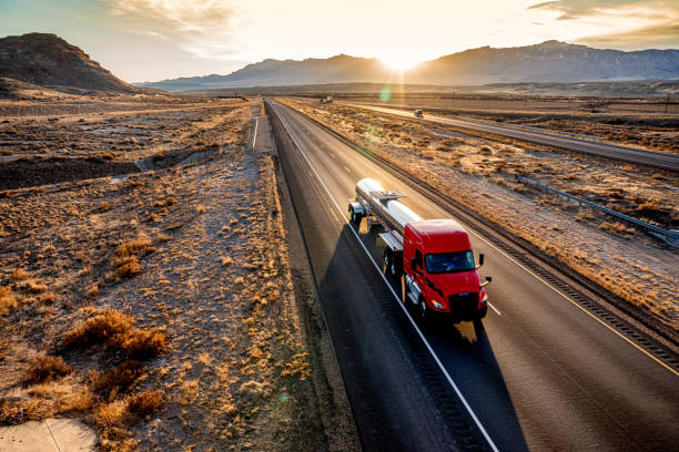 Red Cab Tanker Truck Speeding Down Interstate Seventy in Utah Red Cab Tanker Truck Speeding Down Interstate Seventy in Utah during a beautiful sunset heading eastbound in the desert fuel truck photos stock pictures, royalty-free photos & images