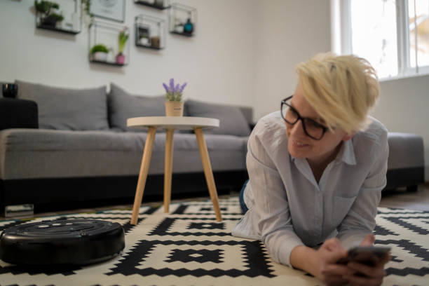 istock One woman, at home relaxing, while robot vacuum cleaner is working 1289933464