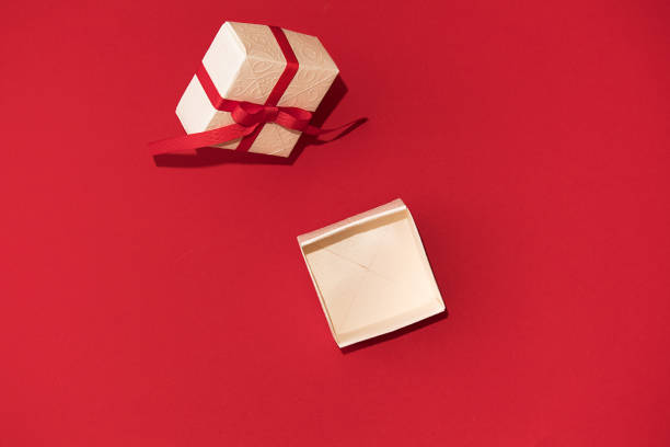 istock White gift box with red ribbon on red background 1289934174