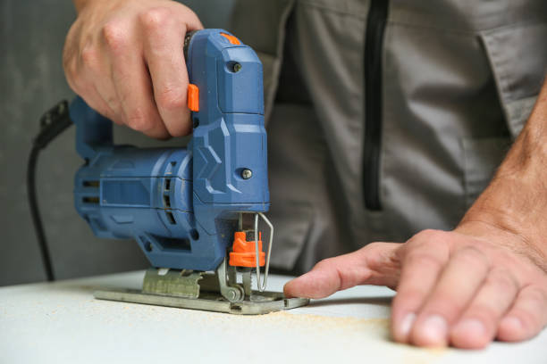 istock repairman's hand is sawing with electric jigsaw 1289934681