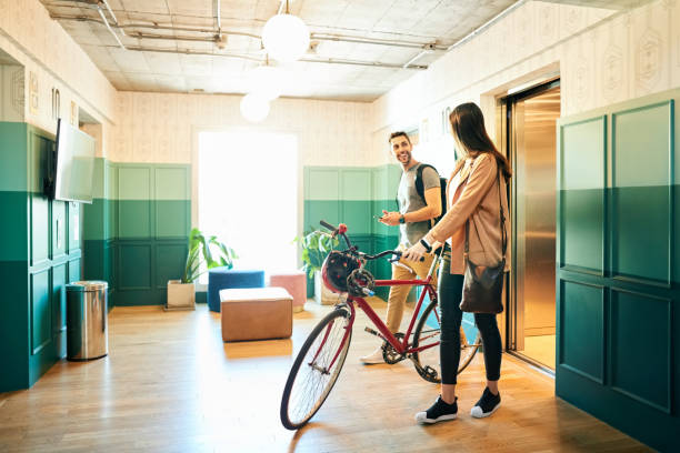 Arriving at job Young coworkers arriving in office with bicycle returning home from work stock pictures, royalty-free photos & images