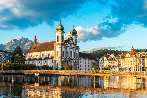 09/05/2020 Lucerne, canton lucerne, switzerland - the church on the shore of the river Reuss in the city center of lucerne in sunrise light and colorful clouds in the sky. in the background the Pilatus mountain, landmarks of the city