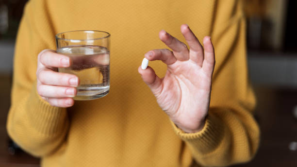 istock Young woman holding white pills in hands 1289937157