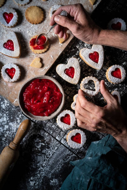 istock Lincer cookies preparation man hands put strawberry jam with spoon 1289937364