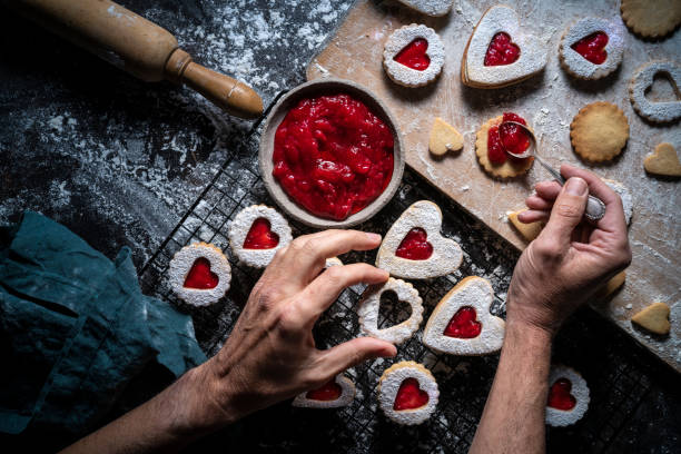 istock Lincer cookies preparation man hands put strawberry jam with spoon 1289937385