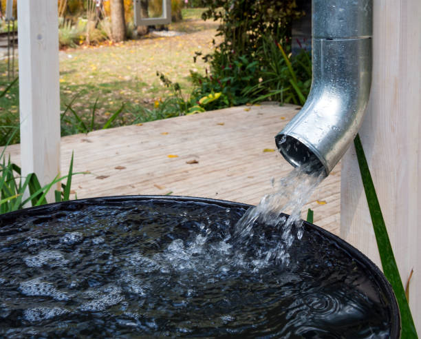 Water drains from the drain pipe into a metal container Water drains from the drain pipe into a metal container harvesting stock pictures, royalty-free photos & images