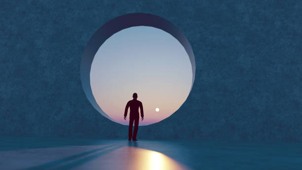 istock Sun sets in the horizon while man walks towards a big round window 1289937777