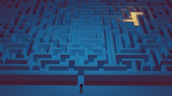 Concept of solving problems. Man stands in front of a big maze and is ready to enter it. There is light in the back of the maze.