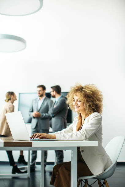istock Young woman CEO working inside modern office while her colleagues discussing in the background 1289939704
