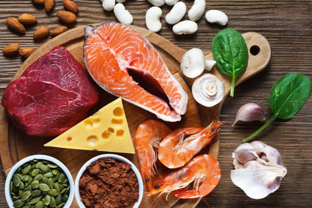 Foods High in Zinc Foods High in Zinc as salmon, seafood-shrimps, beef, yellow cheese, spinach, mushrooms, cocoa, pumpkin seeds, garlic, bean and almonds. Top view zinc stock pictures, royalty-free photos & images