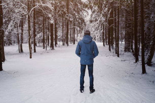 istock A man breathes deeply in the calm winter forest on a cold day. 1289944068