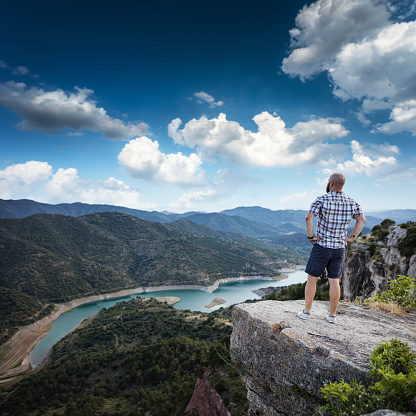 Man stands alone on at the edge of the mountain