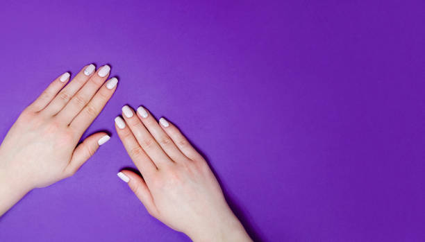 istock Female manicure on a bright background. Purple 1289948091