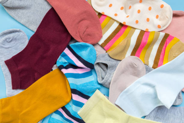 istock Many multicolored new socks stacked against a blue background. top view. place for text. 1289948395