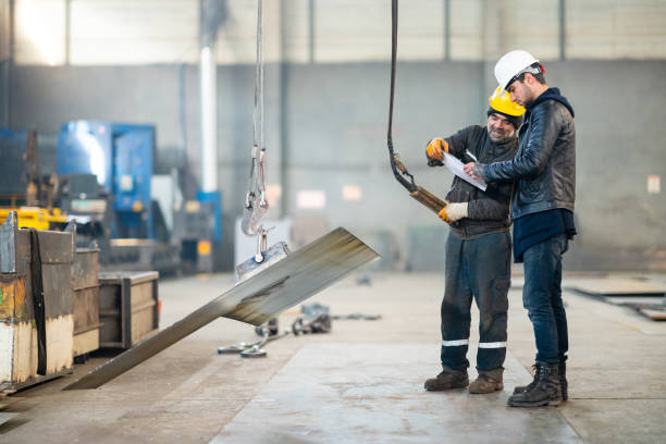 Young engineer checks what the factory worker using cable winch does from the checklist