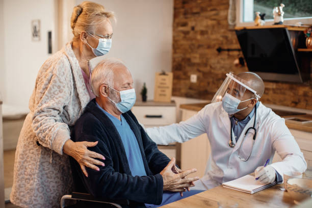 coppia senior che ha fatto visita a casa dal medico afroamericano durante la pandemia di coronavirus. - nursing home senior adult group of people home caregiver foto e immagini stock