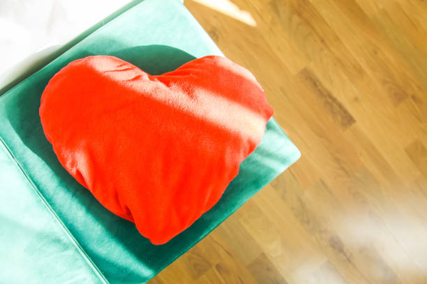 istock Heart shaped small decorative pillow on soft green pouffe 1289950938
