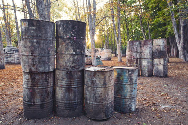 istock Lots of old round barrels in the paintball base 1289951292