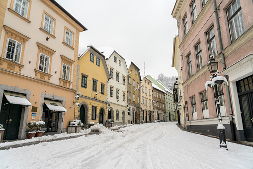 Empty snowy street in old part of Ljubljana in day time.