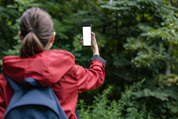 istock Hiking in nature and looking at smart phone. White screen 1289953709